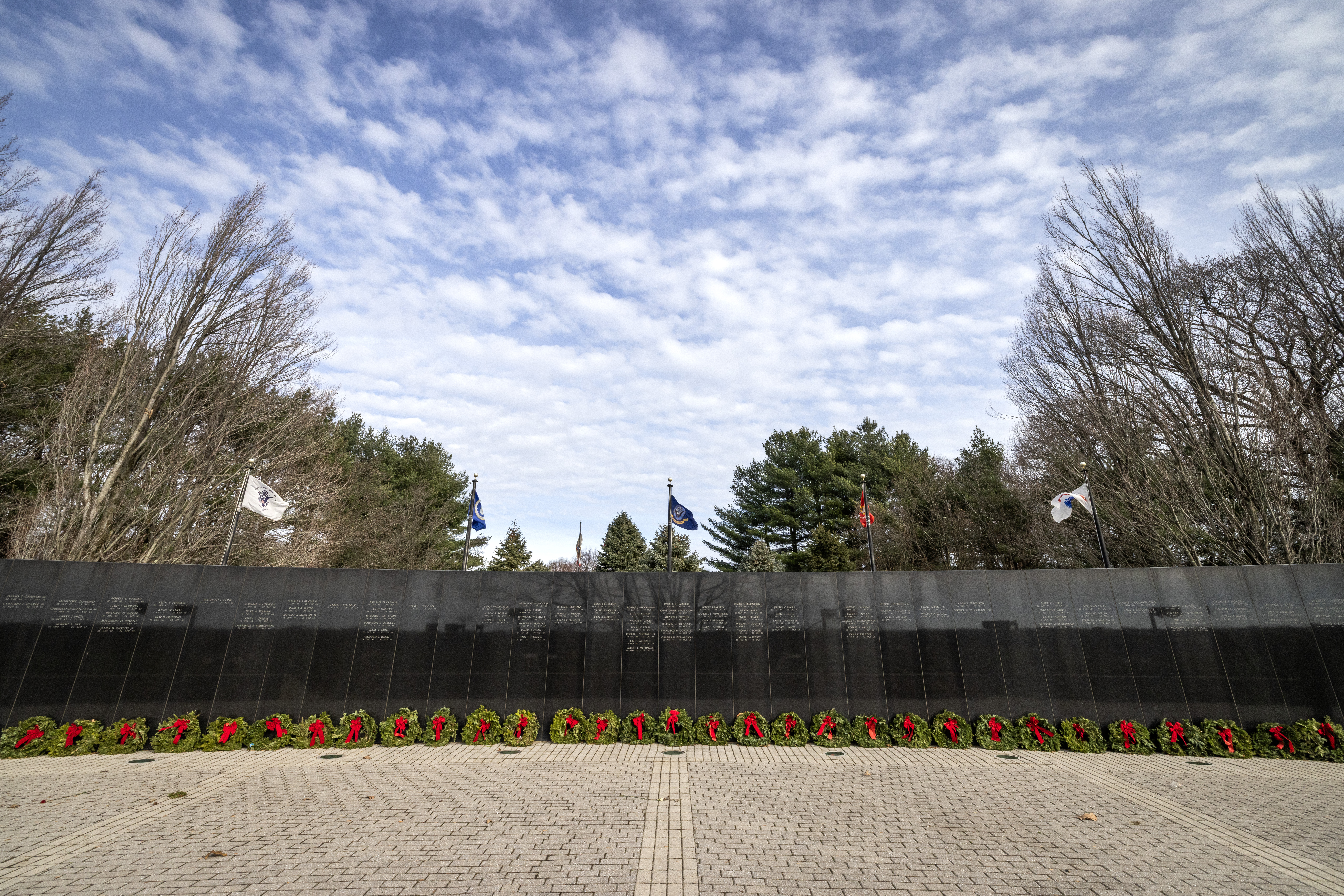 Wreaths were placed at the New Jersey Vietnam Veterans Memorial in Holmdel, New Jersey, Dec. 10, 2025. The wreaths were placed at the base of each of the memorial’s 366 eight-foot-tall black granite panels – each representing a day of the year – listing the names of the 1,564 New Jersey men and one woman who gave their lives while serving in Southeast Asia. In addition, the Wreaths Across America convoy stopped at the memorial on their annual journey to Arlington National Cemetery. This year marks the 50th anniversary of the end of the Vietnam War. (New Jersey Department of Military and Veterans Affairs photo by Mark C. Olsen)