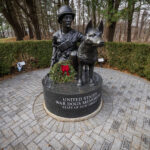 A wreath is placed at the U.S. War Dogs Memorial at the New Jersey Vietnam Veterans Memorial in Holmdel, New Jersey, Dec. 10, 2025. Wreaths were placed at the base of each of the memorial’s 366 eight-foot-tall black granite panels – each representing a day of the year – listing the names of the 1,564 New Jersey men and one woman who gave their lives while serving in Southeast Asia. In addition, the Wreaths Across America convoy stopped at the memorial on their annual journey to Arlington National Cemetery. This year marks the 50th anniversary of the end of the Vietnam War. (New Jersey Department of Military and Veterans Affairs photo by Mark C. Olsen)